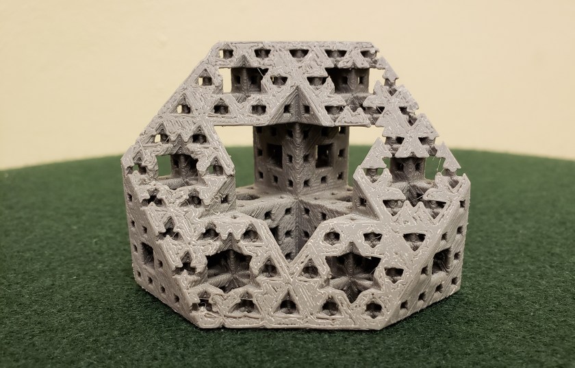 A 3D printed Menger Sponge cut in half to reveal the inner structure.